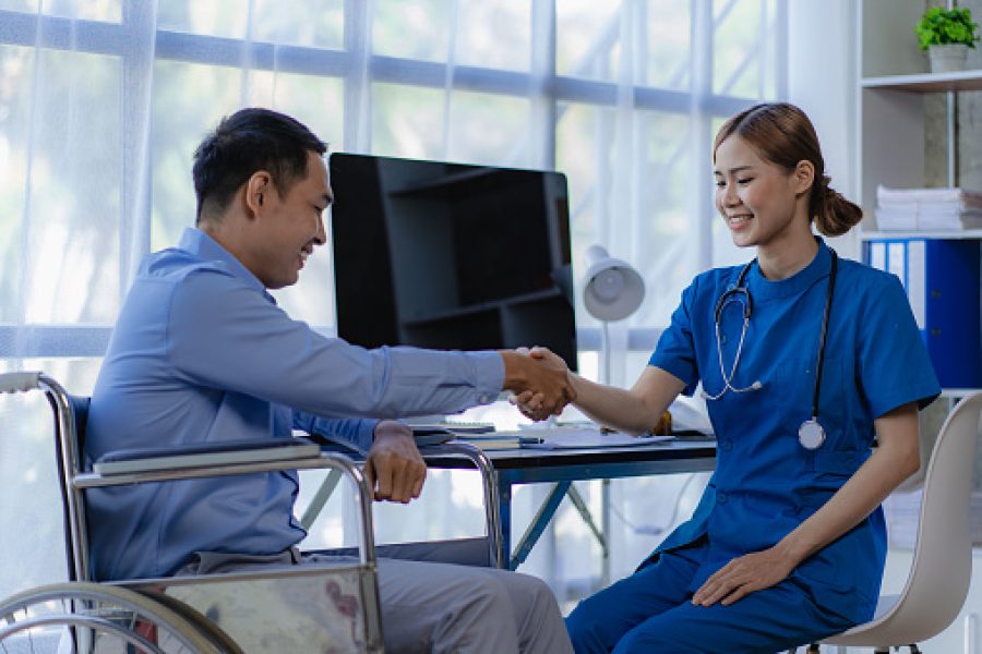 Asian female doctor holding patient's hand to greet and respect doctor, health consultation and treatment concept